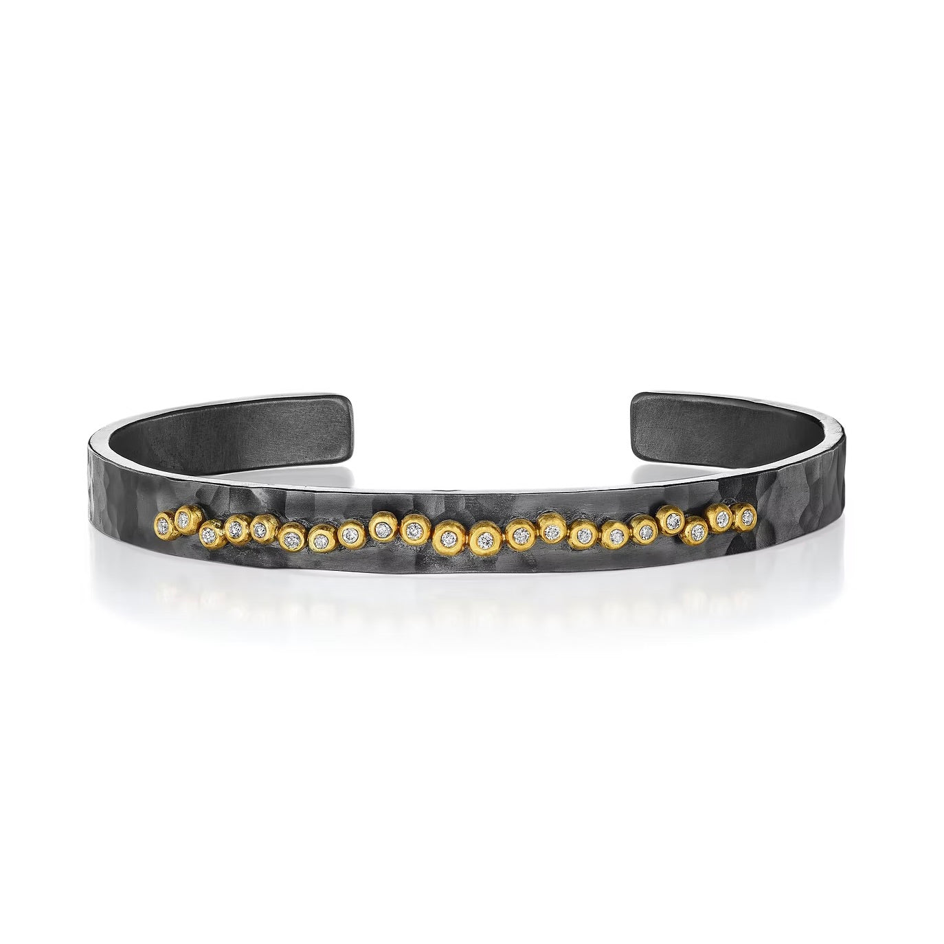 Narrow oxidized sterling silver cuff with diamonds set in 18k yellow gold forming a gentle freeform line of decoration