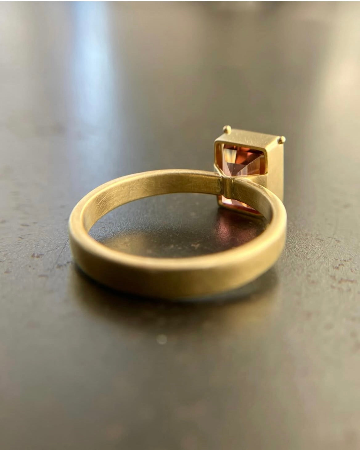 Rear view of Aarectangular pink ombre tourmaline stone ring in gold setting.