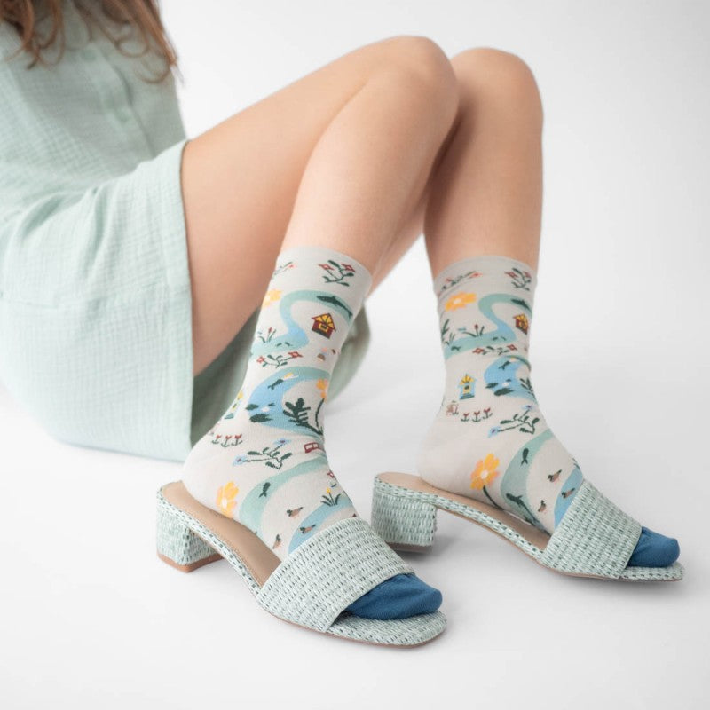 person wearing pair of socks with woodland trail motif