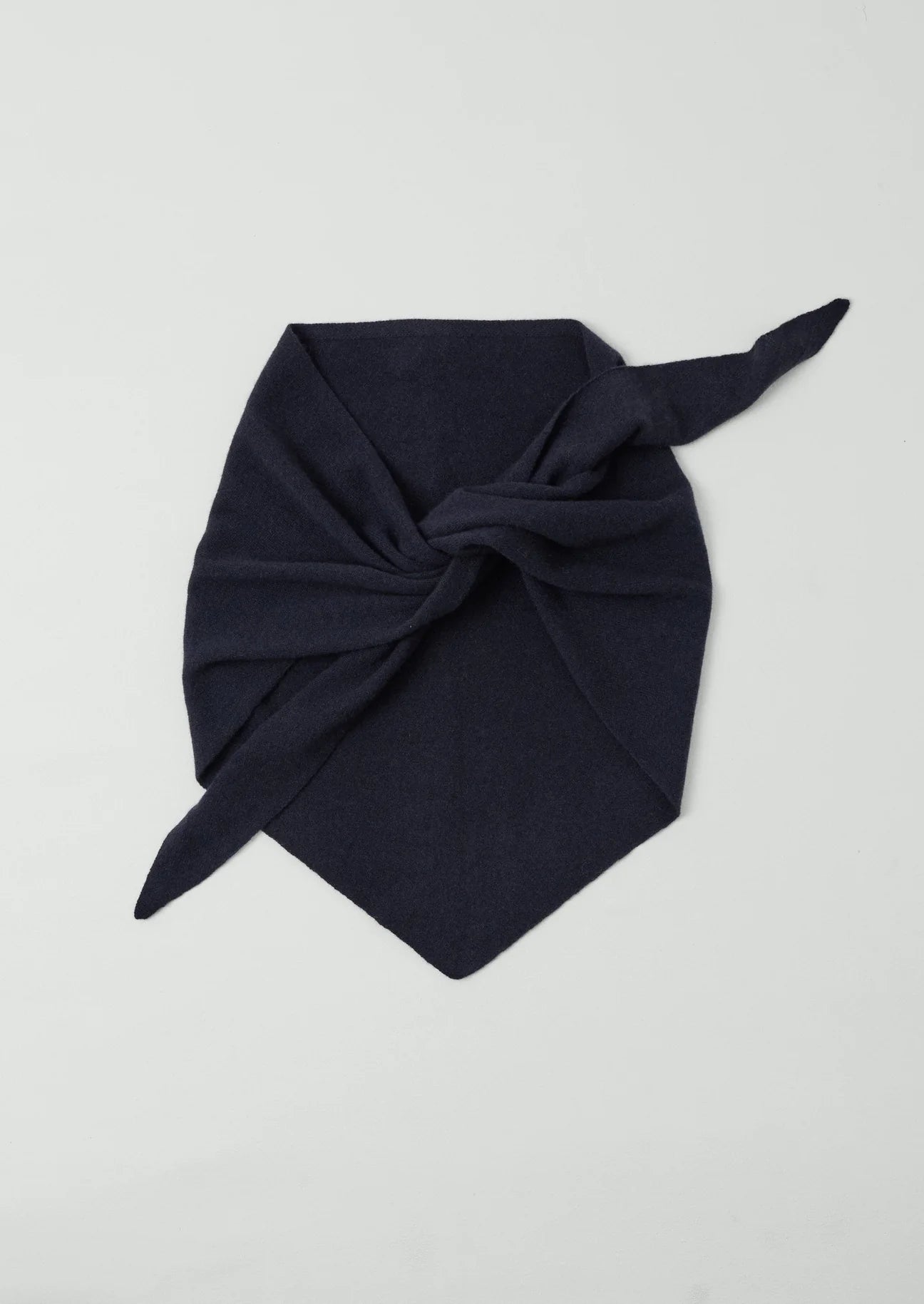 Navy blue knotted headscarf on a light gray background