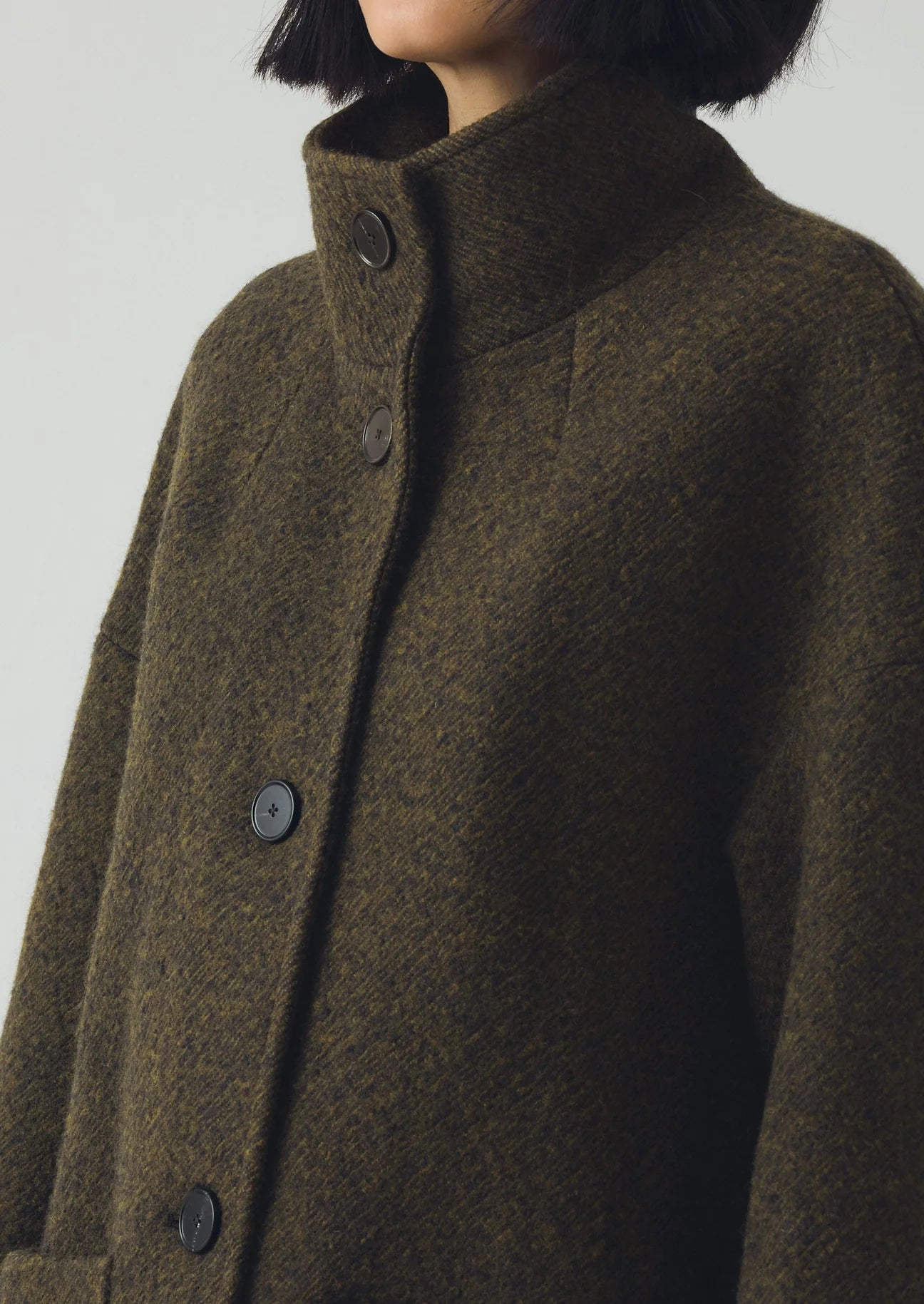 Brown coat with button details on a plain background