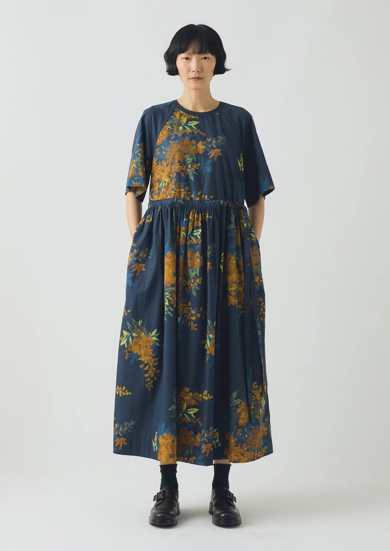 Woman wearing a dark blue floral dress on a white background