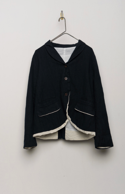 Shown hanging flat on a hook against a white background, a softly tailored pinstripe jacket by HANNOH WESSEL, cut with a relaxed, slightly cropped silhouette and a gently curved hem.