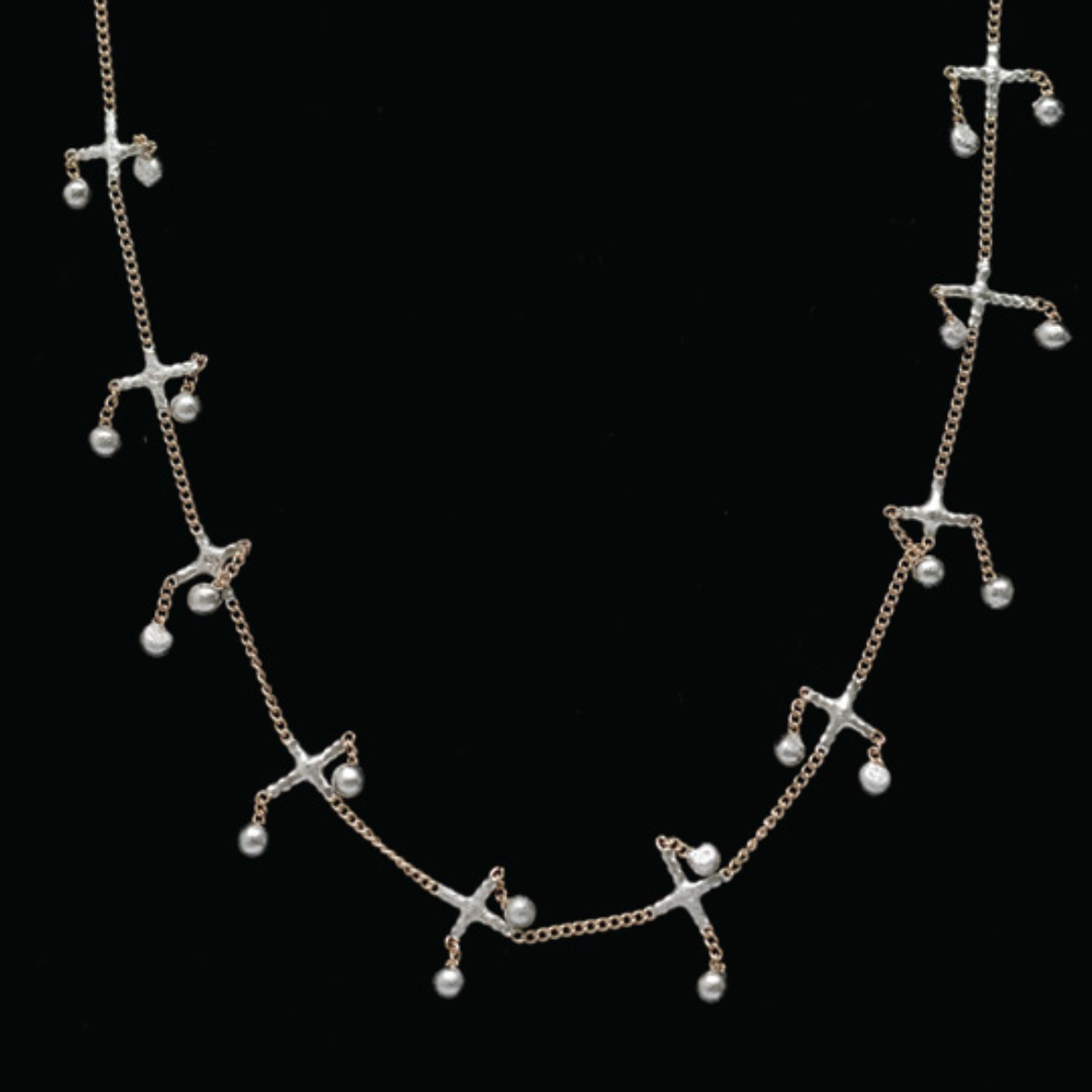 Silver necklace with star-shaped pendants on a black background