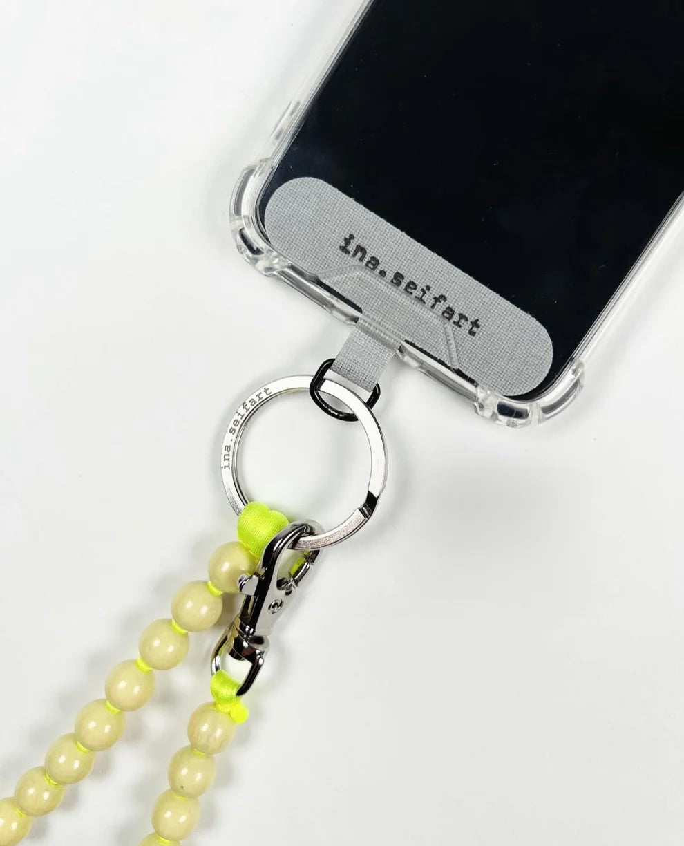 Phone case with a beaded lanyard and clear back on a white background
