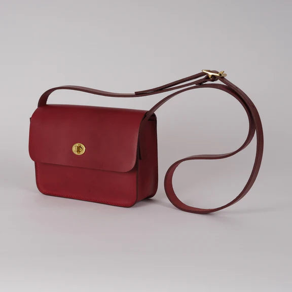 Picture of red leather handbag on flat grey background