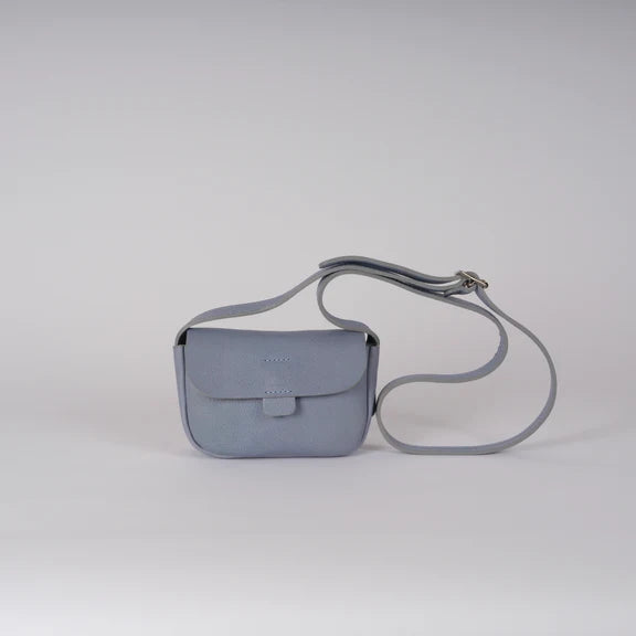 Picture of cornflower blue handbag front view. On plain grey background.