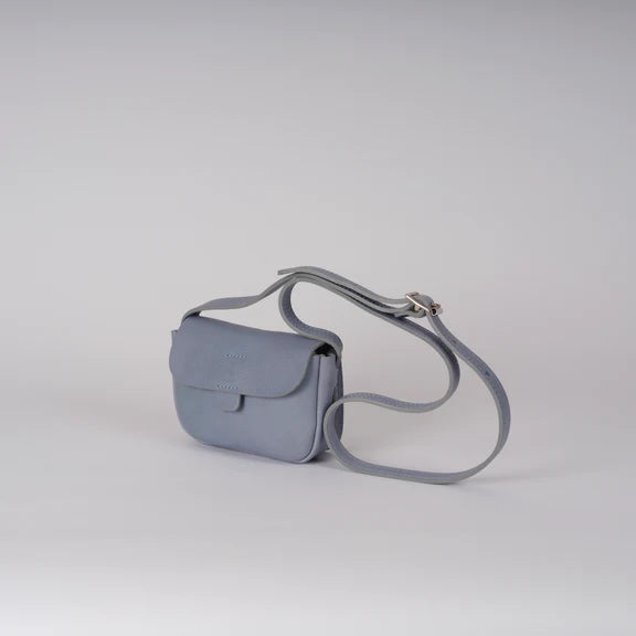 Picture of cornflower blue handbag side and front view. On plain grey background.
