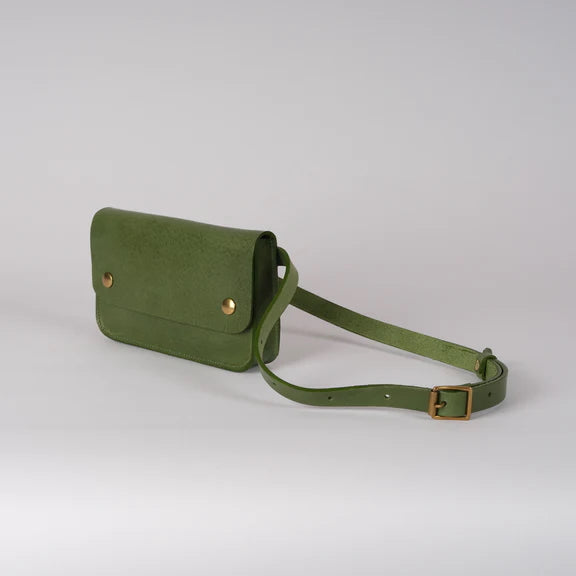 Picture of green handbag on grey background. Font and side view.