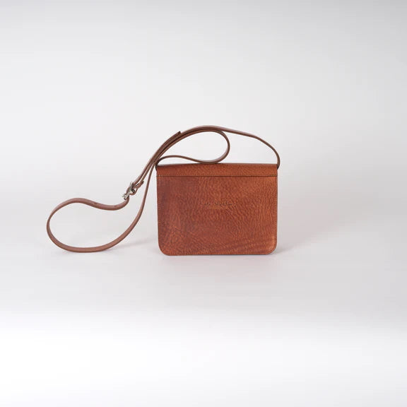 Picture of the back of a brown leather handbag on a plain white background.