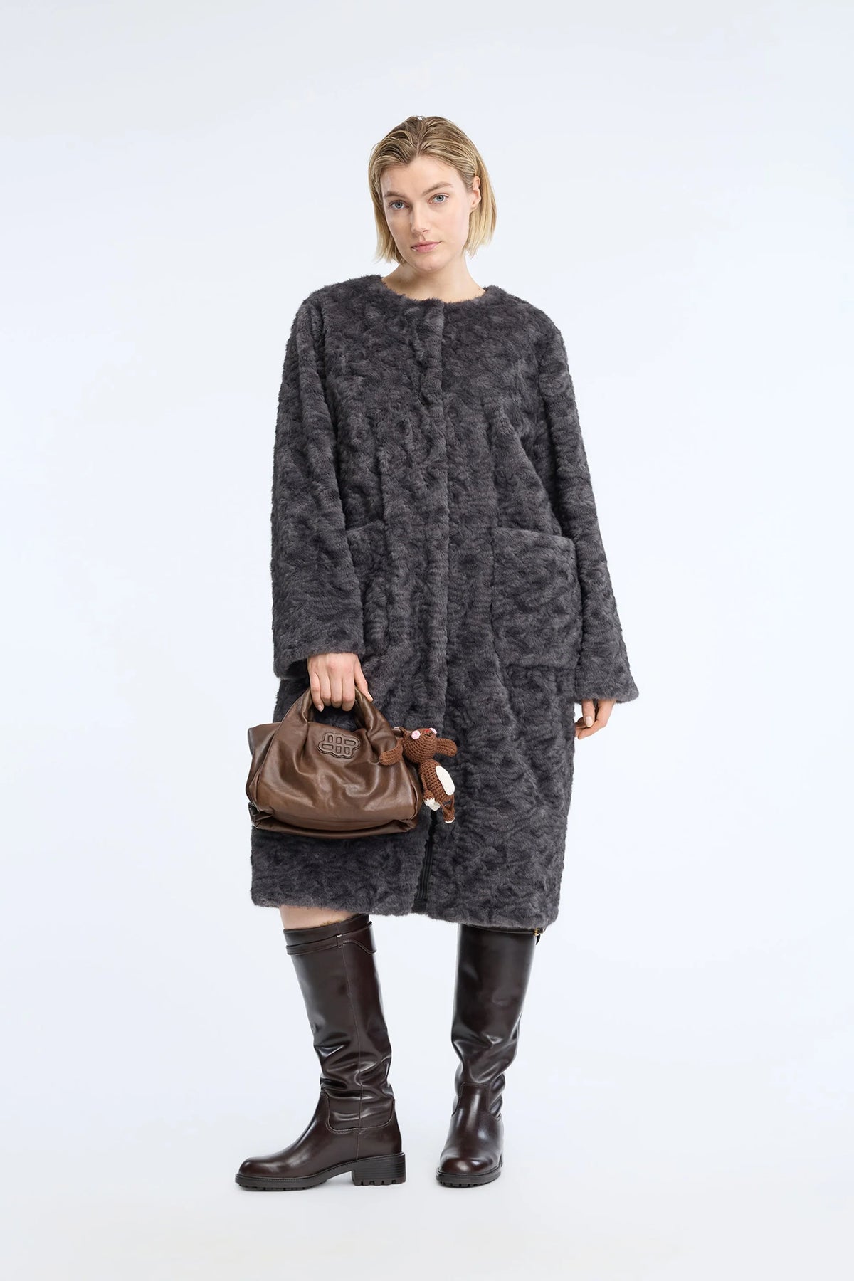 A dark gray textured fleece jacket with a subtle tonal pattern, worn on a posing model.