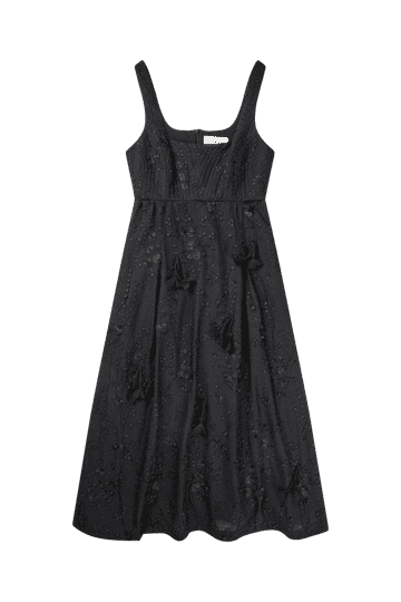 A black dress with narrow straps embellished with floral applique all over.