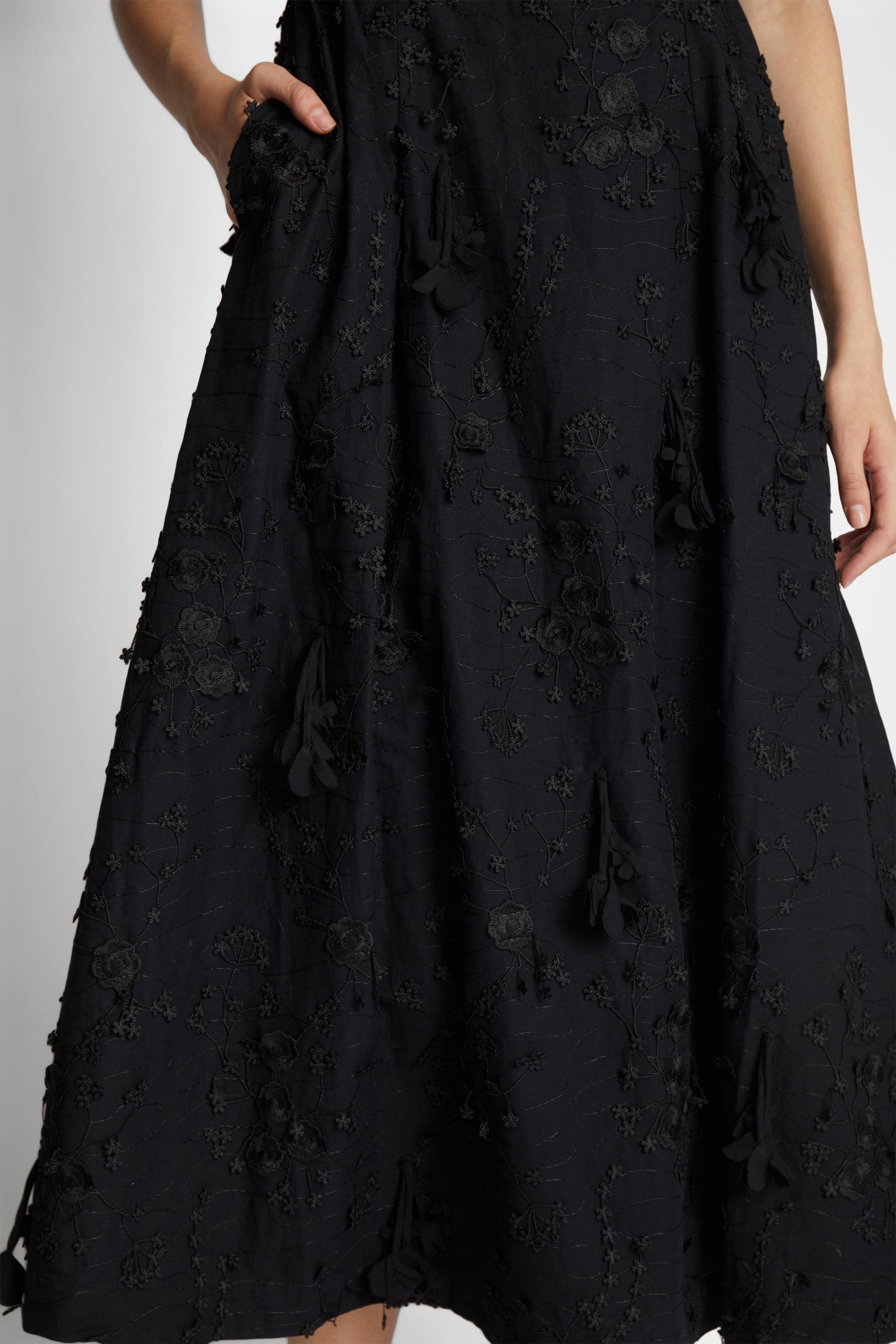 detail of applique floral decoration on a black dress.