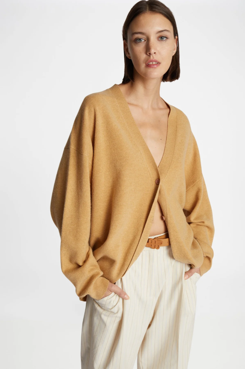 woman modeling light camel colored cardigan with cream colored pants