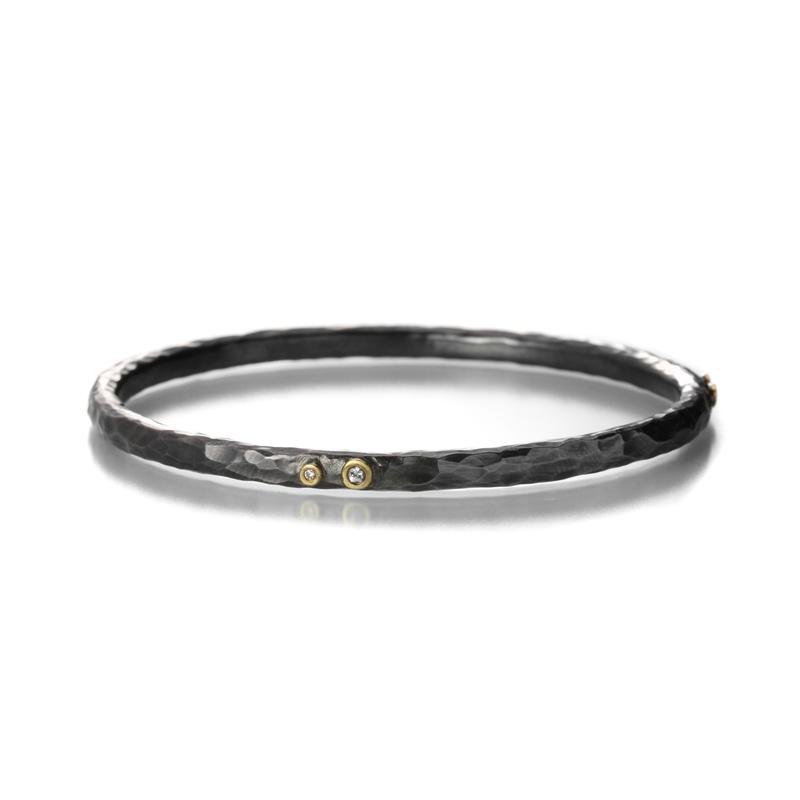Hand fabricated, hammered round bangle in blackened sterling silver and yellow gold with natural fancy colored diamonds.