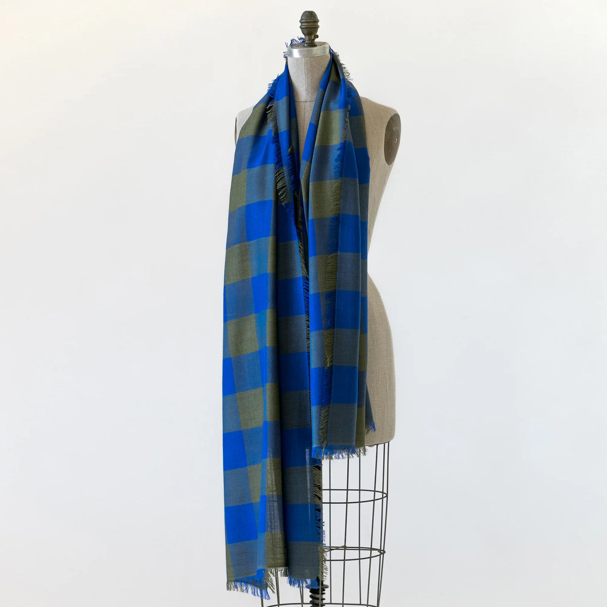 A blue and green checkered gingham scarf shown wrapped around a mannequin.