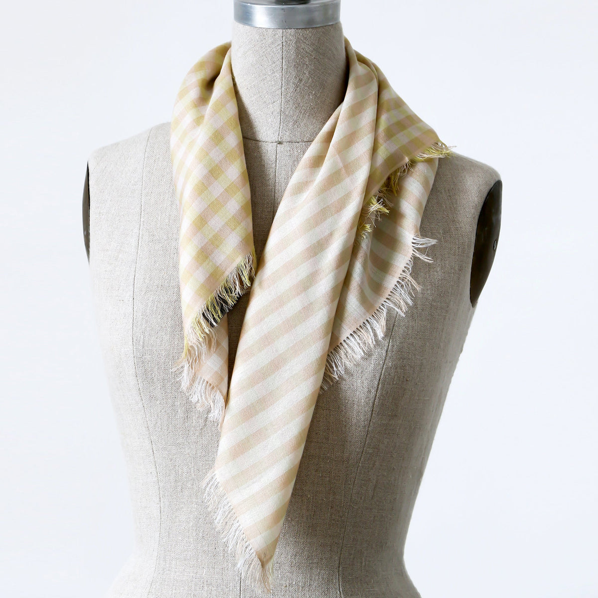 A small beige, white, and chartreuse checkered gingham scarf shown wrapped around a mannequin.