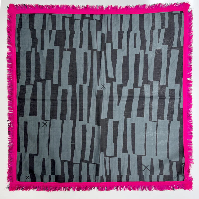 Picture of a square dark grey and charcoal scarf with pink trim laying flat