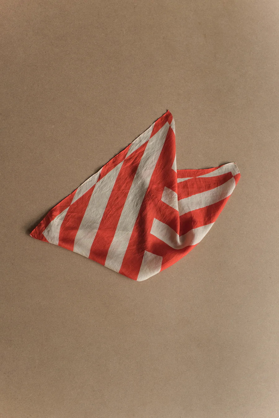 Picture of silk scarf with red stripes. Folded.
