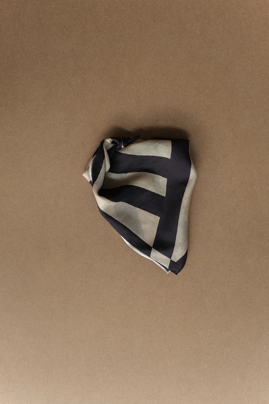 Picture of silk scarf with dark indigo stripes. Folded into kite shape.