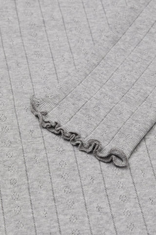 Close-up of a gray ribbed sweater with a decorative edge.