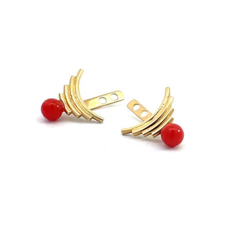 A pair of gold-toned curved ear jackets with a small round coral bead at the end, shown on a plain white background.