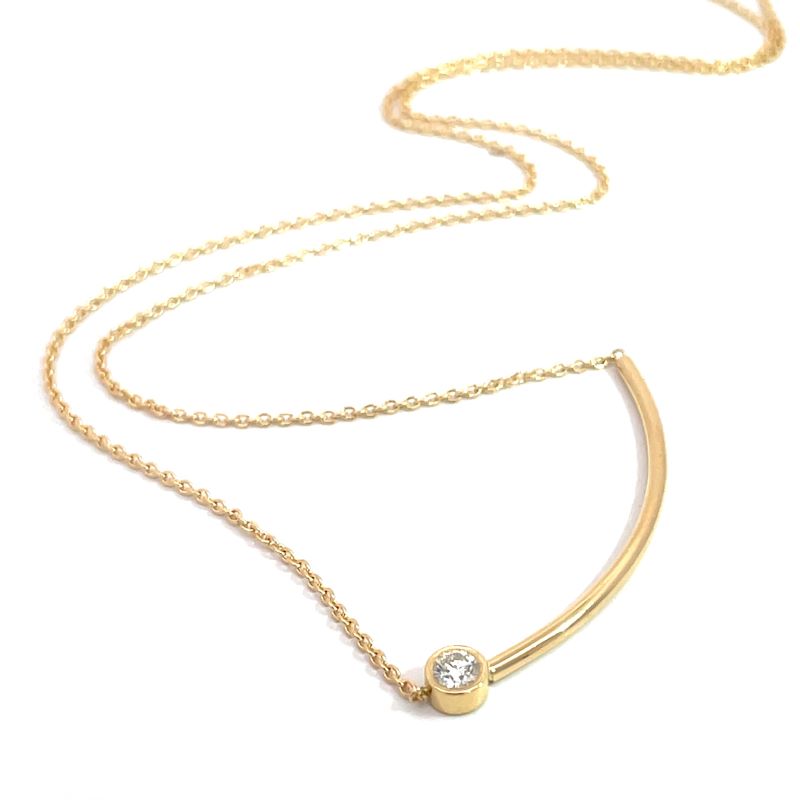 A delicate gold necklace featuring a curved bar pendant with a single bezel-set diamond, displayed on a clean white background.