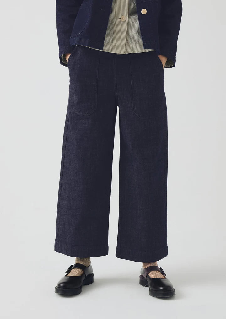 Person wearing navy wide-leg pants with a plain background