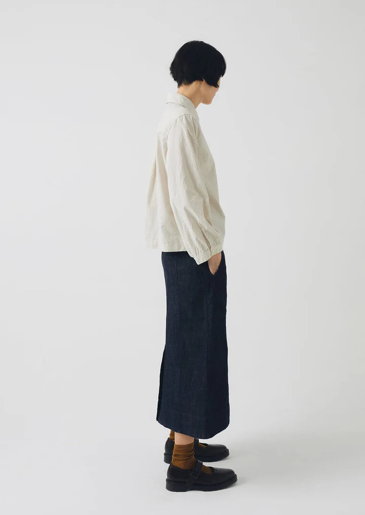 Person wearing a white shirt and dark pants on a white background