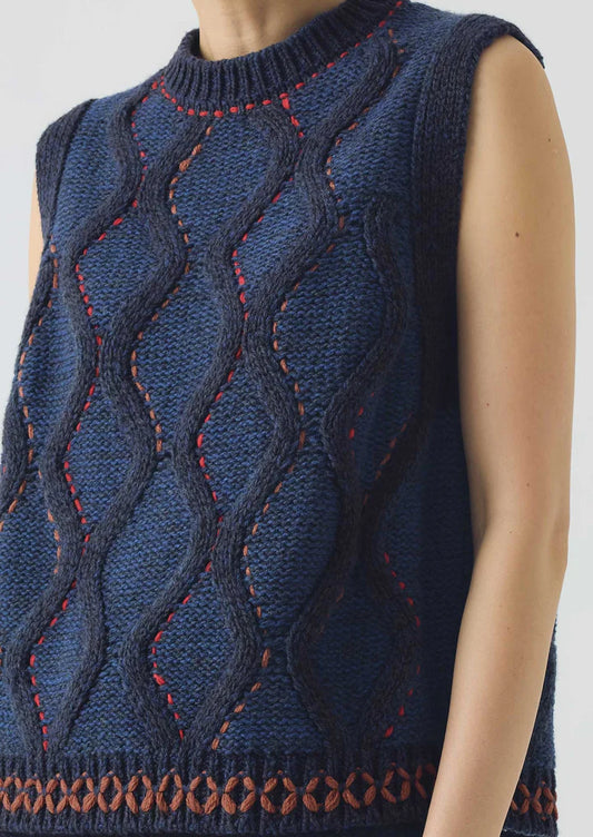 Blue knitted vest with red stitching on a plain background