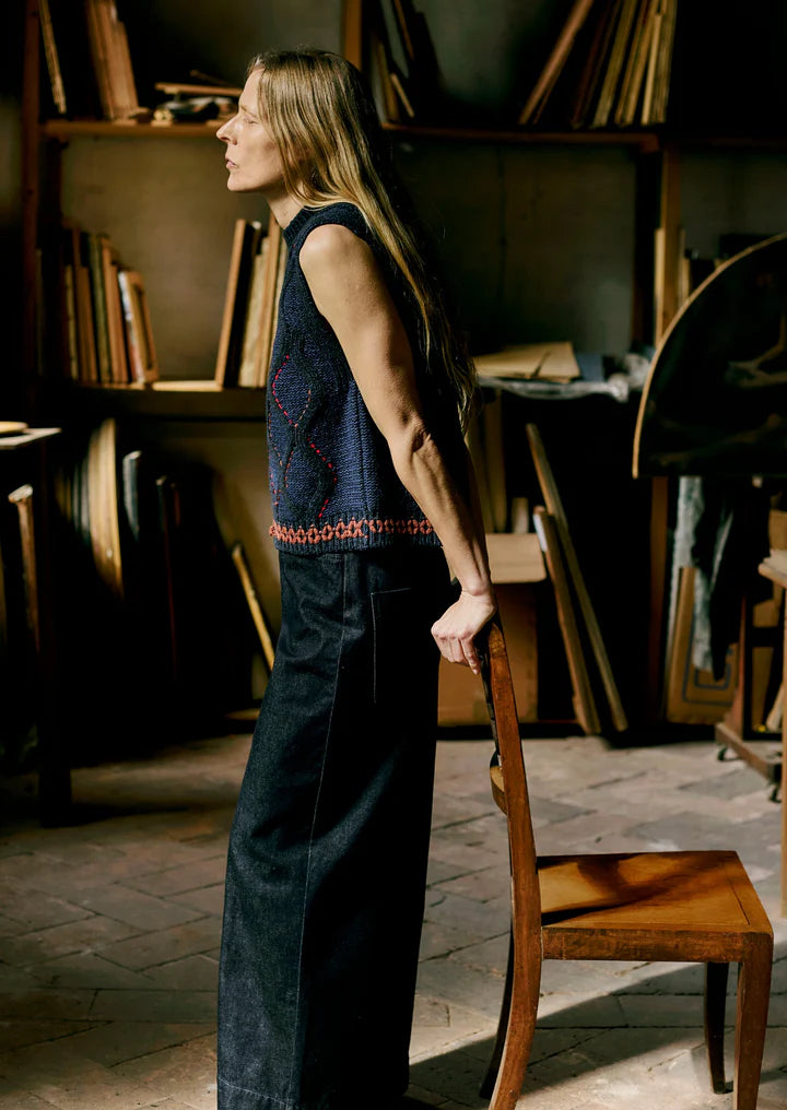 Woman standing in a room with bookshelves and wooden furniture