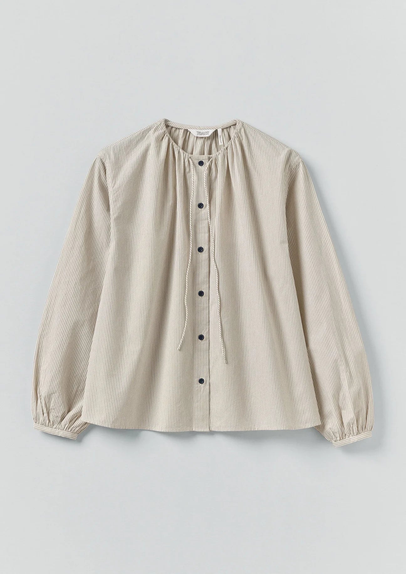 Beige blouse with long sleeves on a light gray background