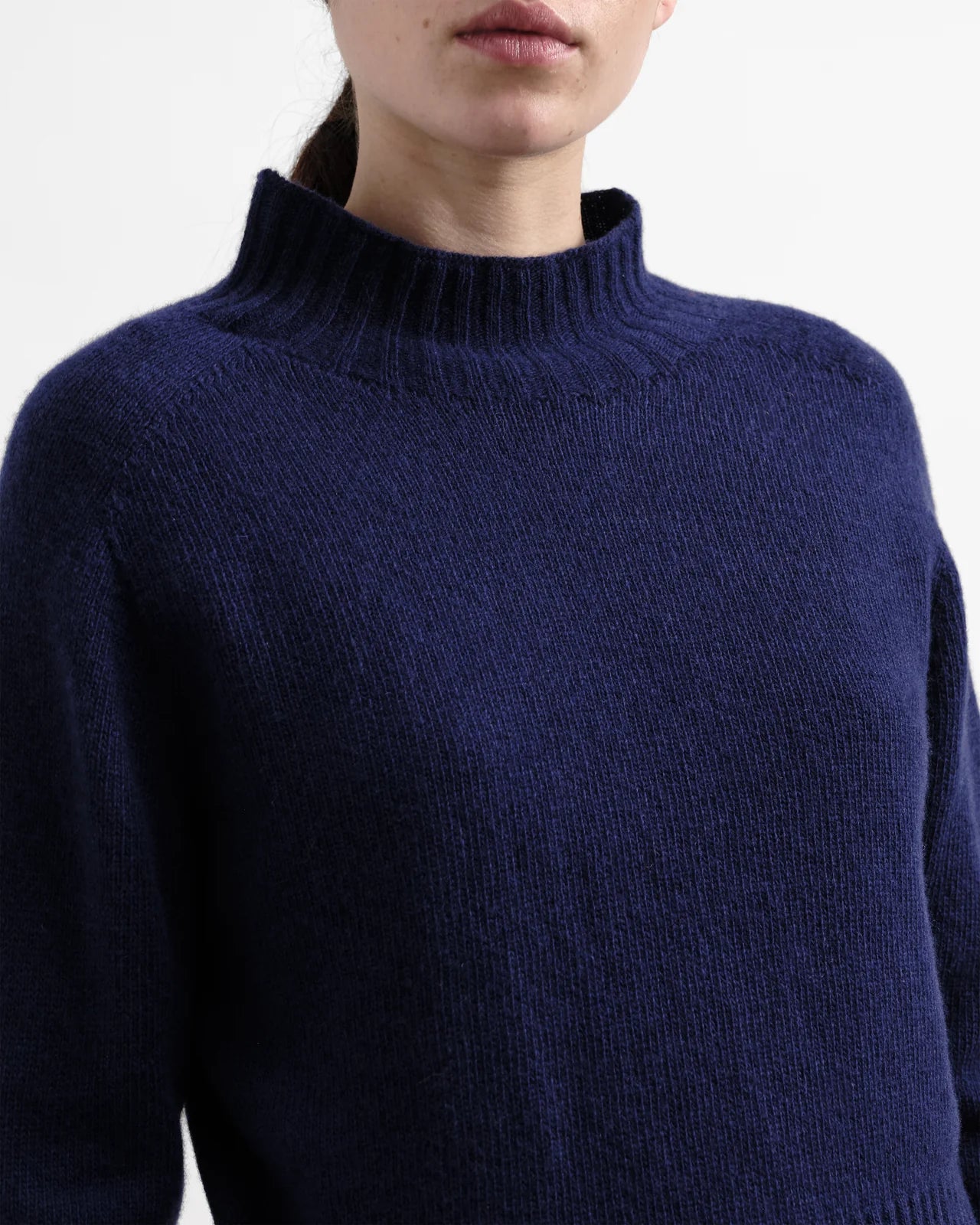 Navy blue sweater worn by a person on a white background