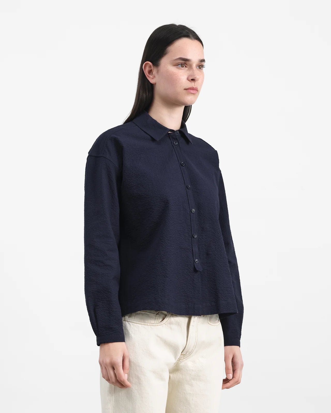 Person wearing a navy blue shirt with a white background