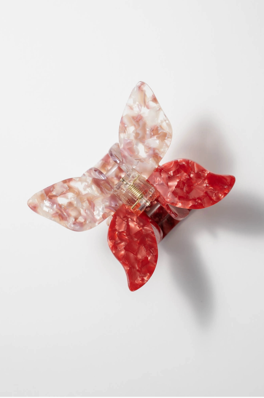 Butterfly shaped hair clip in pink and speckled white and pink.