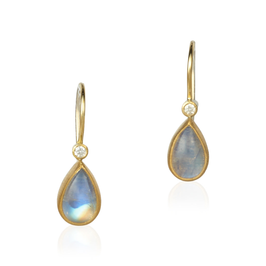 image of a pair of teardrop shaped moonstone earrings with a diamond set in gold on ear wires.