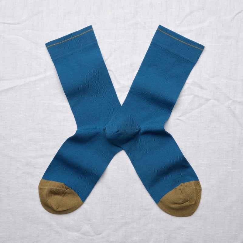 Pair of blue socks with brown toes and cuffs on a white background