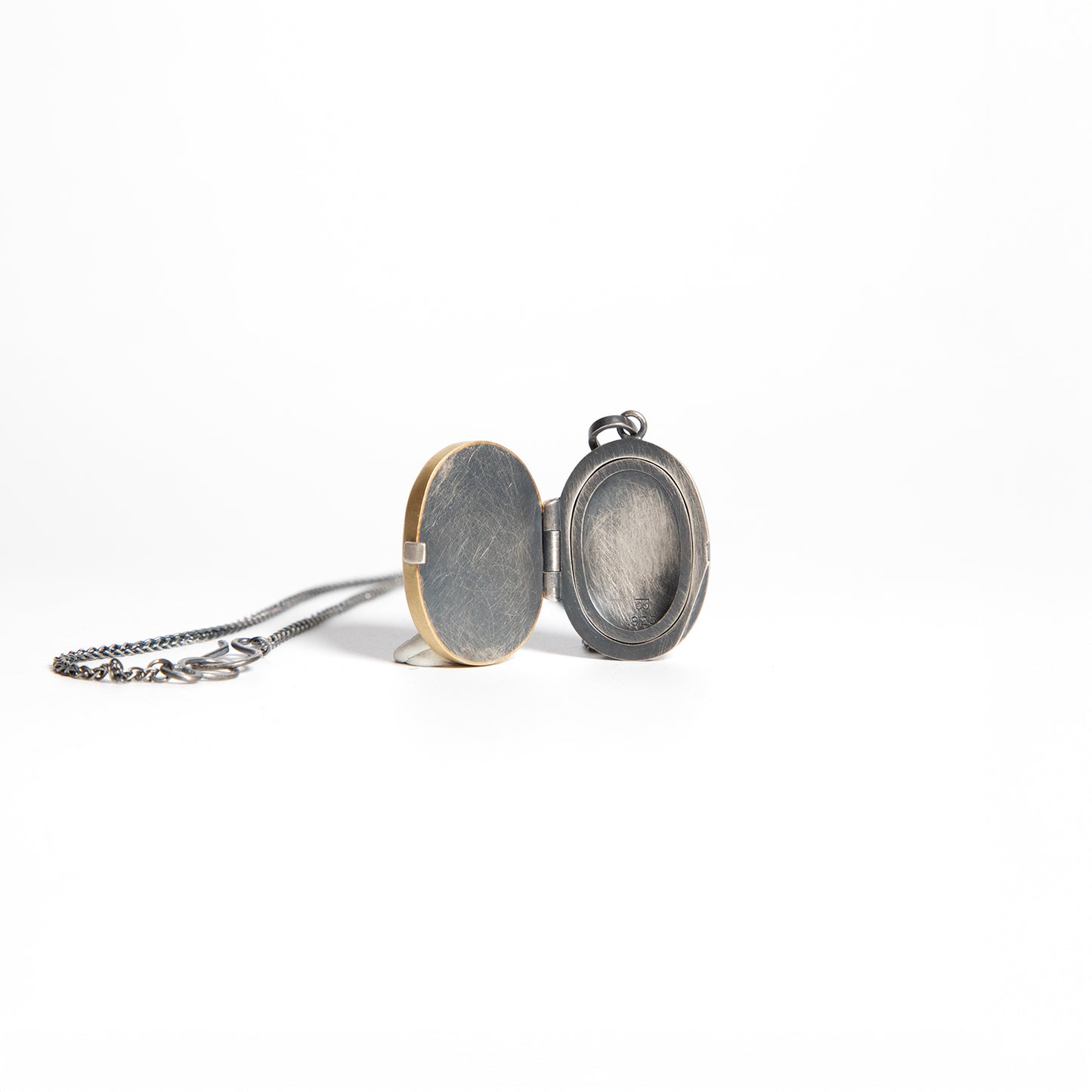 Two round locket pendants on a white background