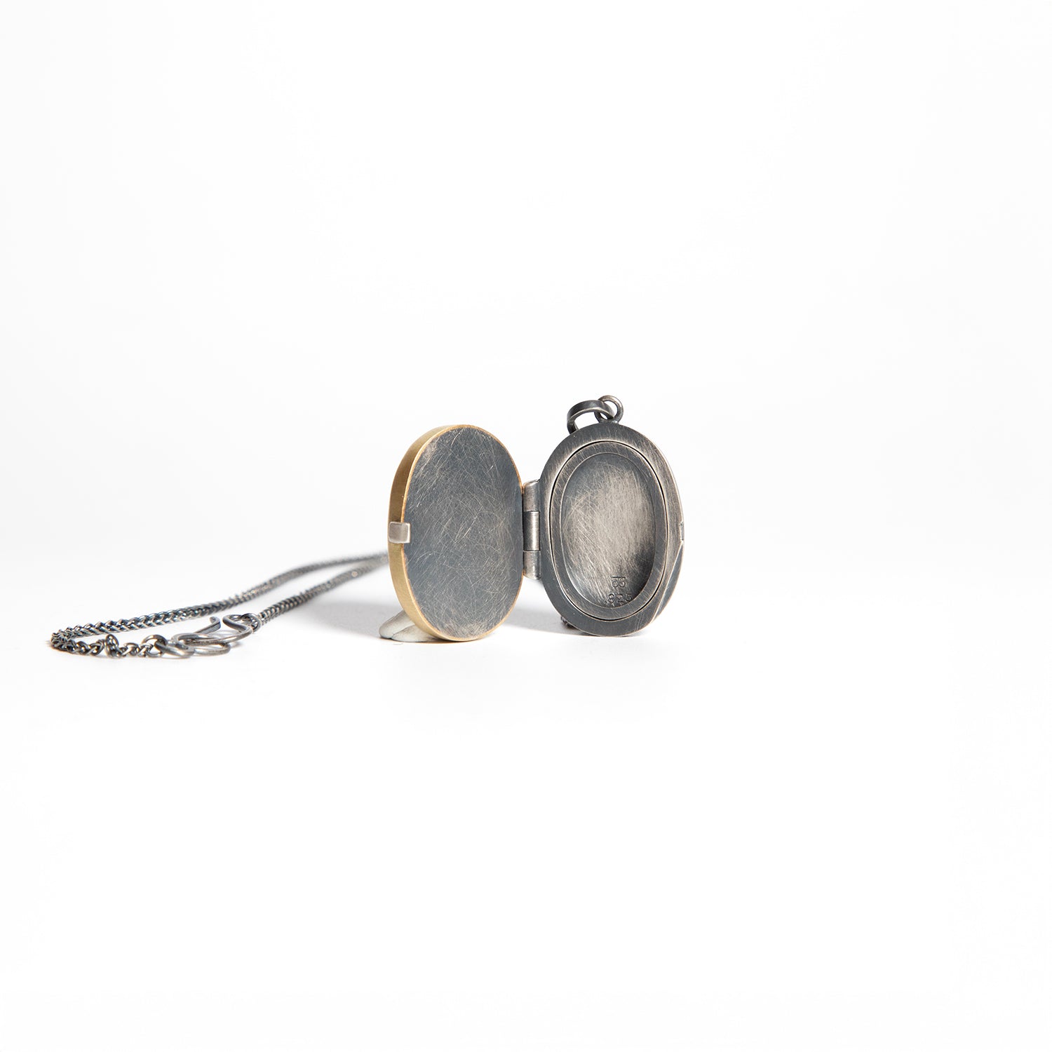 Two round locket pendants on a white background