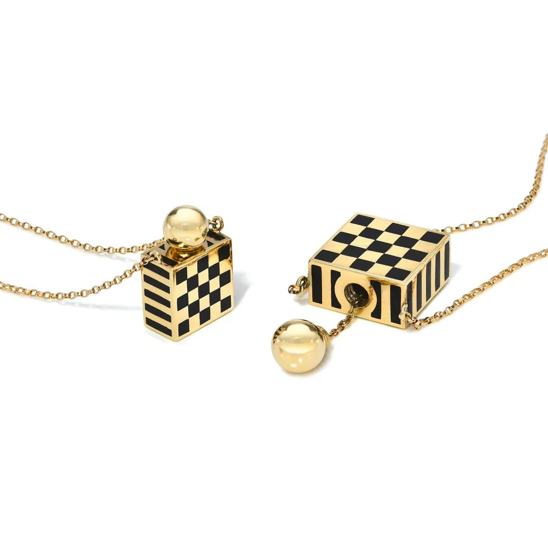 Two gold necklaces with checkered cube pendants on a white background