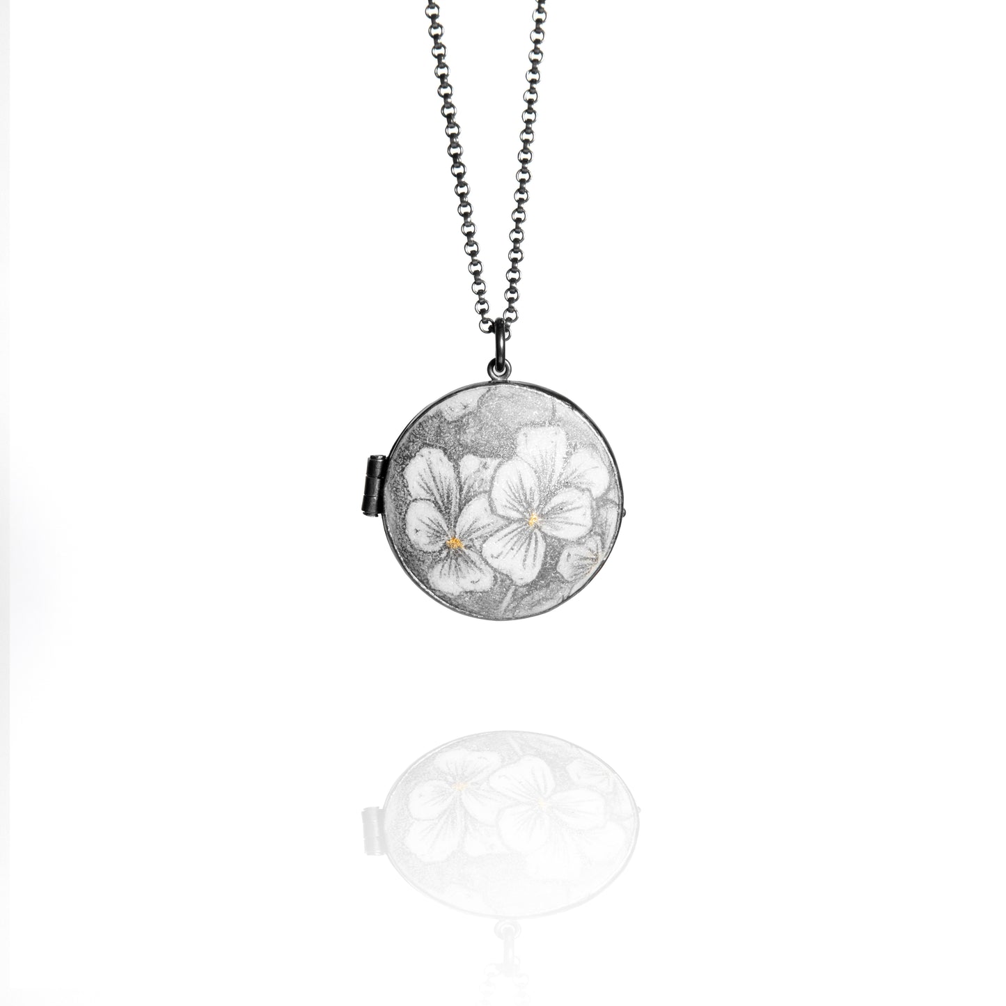 Necklace with a round locket featuring floral design on a white background