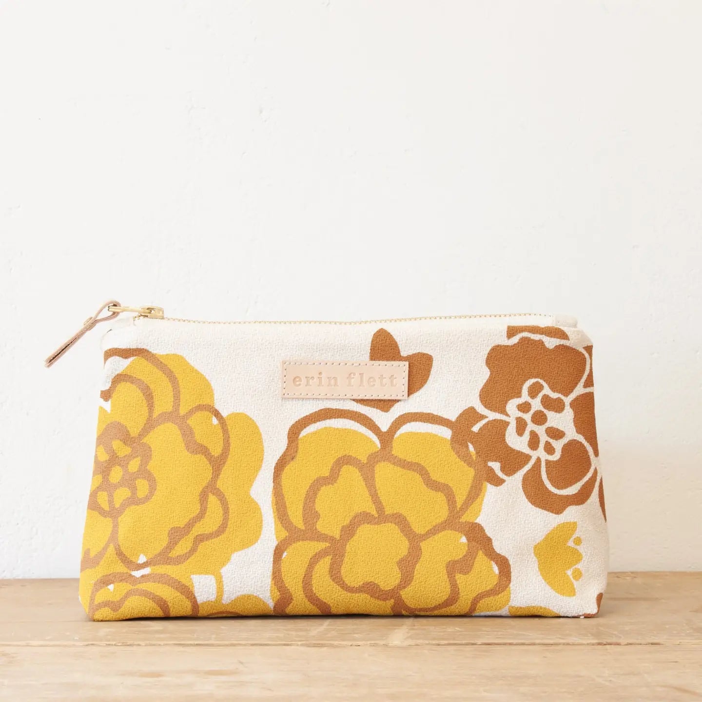 Floral-patterned pouch with a visible brand label on a white background