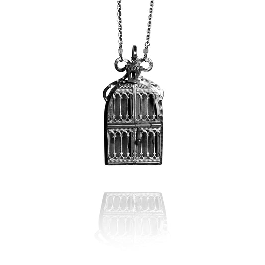 Silver birdcage pendant necklace on a white background