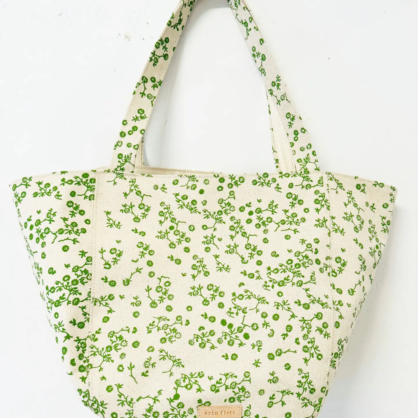 Tote bag with green floral pattern on a white background