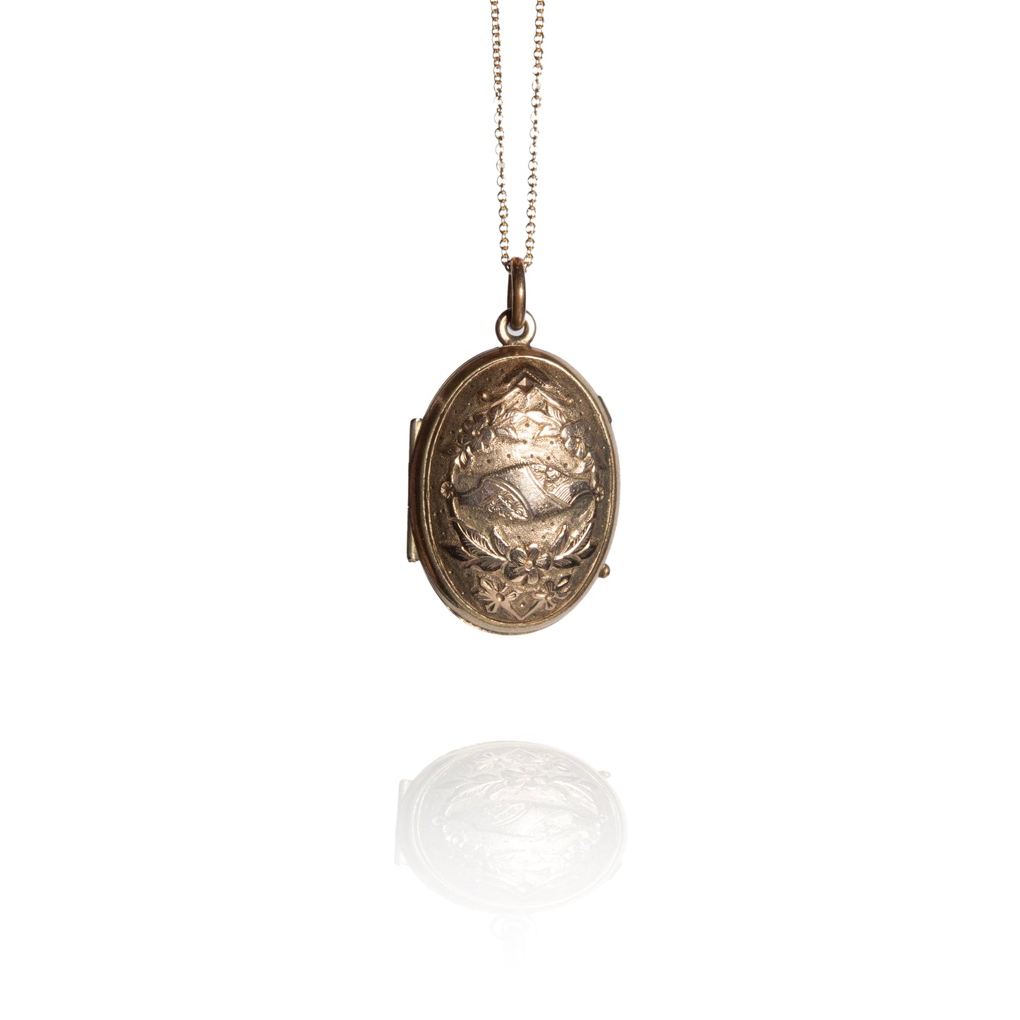 Gold locket on a chain against a white background
