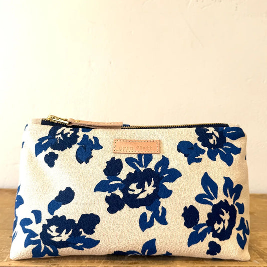Floral-patterned pouch with a zipper on a wooden surface