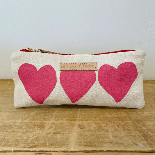 Pouch with pink hearts on a wooden surface