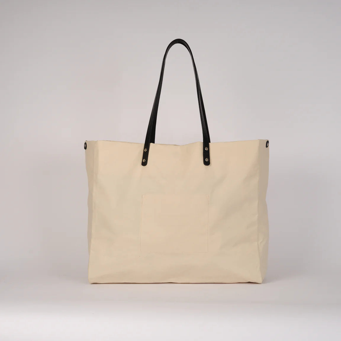 Beige tote bag with black handles on a light gray background