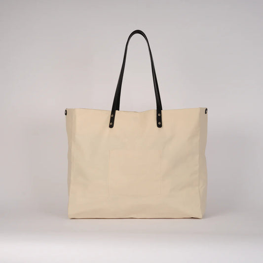 Beige tote bag with black handles on a light gray background