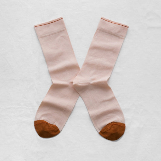 Pair of light pink socks with brown toes and heels on a white background
